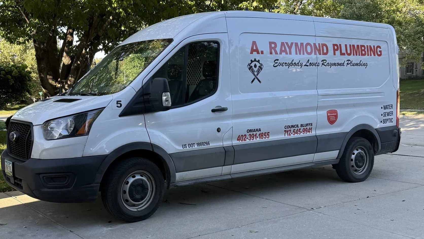 A Raymond Plumbing service van with the Omaha and Council Bluffs phone numbers on the side
