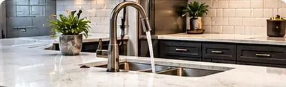 Remodeled kitchen sink with a tall faucet and stone counters